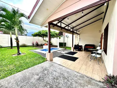 an outdoor patio with awning and a table and chairs at Oasis Arenal Villa Pool & Arenal Volcano View in Fortuna
