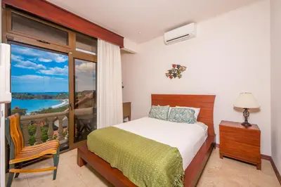 a bedroom with a bed and a large window at Apartamento Del Mar in Playa Flamingo