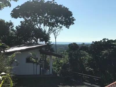 a small white building with a tree in the background at Villas Lambeau #2 Ocean View Fiber Optic in Uvita