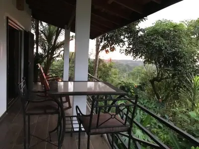 a table and chairs on a balcony with a view at Villas Lambeau #2 Ocean View Fiber Optic in Uvita