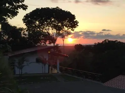 a sunset seen from a house with a balcony at Villas Lambeau #2 Ocean View Fiber Optic in Uvita