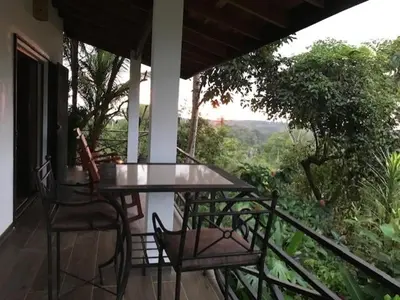 a glass table and chairs on a balcony with a view at Villas Lambeau #2 Ocean View Fiber Optic in Uvita