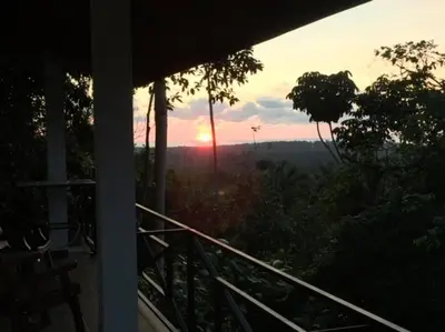 a sunset from the porch of a house at Villas Lambeau #2 Ocean View Fiber Optic in Uvita