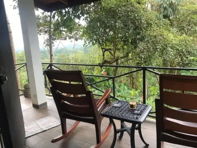 two chairs and a table on a balcony with a view at Villas Lambeau #2 Ocean View Fiber Optic in Uvita