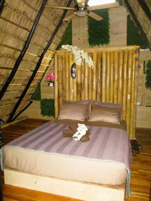 a bed with a teddy bear on it in a room at Cabinas de Lou Eco Lodge TAMARINDO do not book, under maintenance in Santa Rosa