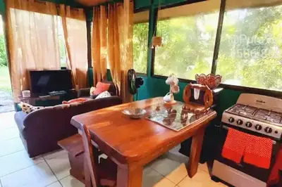 a living room with a table and a stove at Casita Verde, 800 mts from beach in Playa Hermosa
