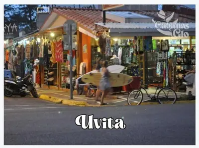 a woman walking down a street with a surfboard at Casita Verde, 800 mts from beach in Playa Hermosa
