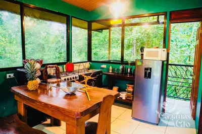a kitchen with a wooden table and a refrigerator at Casita Verde, 800 mts from beach in Playa Hermosa