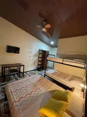 a bedroom with two bunk beds and a ceiling fan at POSADA MIRADIA in Matapalo