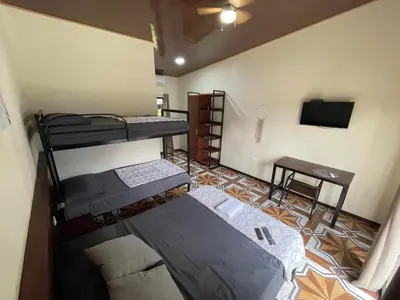 a room with two bunk beds and a television at POSADA MIRADIA in Matapalo