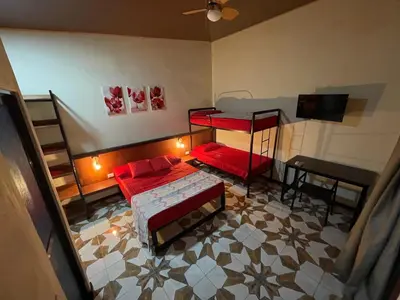 a room with two bunk beds and a table at POSADA MIRADIA in Matapalo