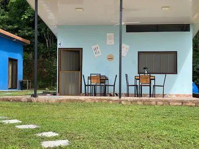 a patio with two chairs and a table in a house at POSADA MIRADIA in Matapalo