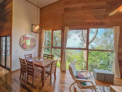 a dining room with a table and chairs and a large window at Casa Por Fin in Monteverde Costa Rica
