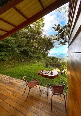 a patio with a table and chairs on a deck at Casa Por Fin in Monteverde Costa Rica