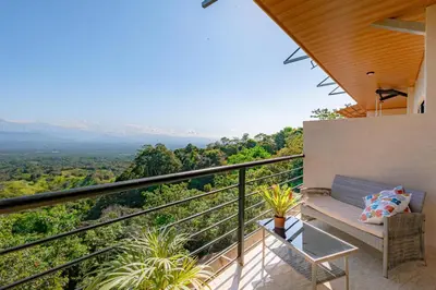 a balcony with a bench and a view of the mountains at Mountain Top Park Hotel in Manuel Antonio