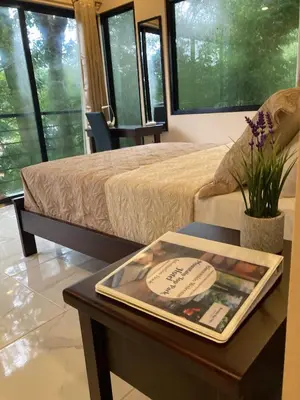 a room with a bed and a table with a book on it at Mountain Top Park Hotel in Manuel Antonio