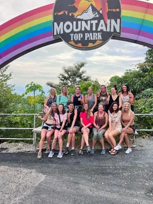 a group of people sitting on a bench under a rainbow at Mountain Top Park Hotel in Manuel Antonio