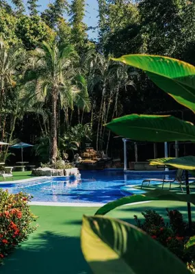 a swimming pool with palm trees and a large swimming pool at Hotel y Restaurante El Páramo in San Rafael Norte