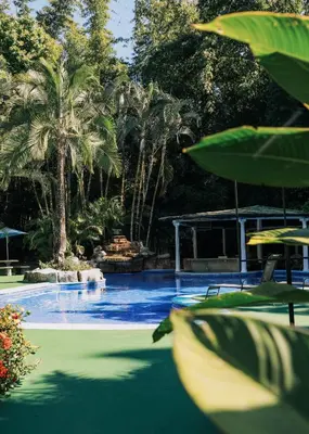 a swimming pool with palm trees and a swimming poolintendent at Hotel y Restaurante El Páramo in San Rafael Norte