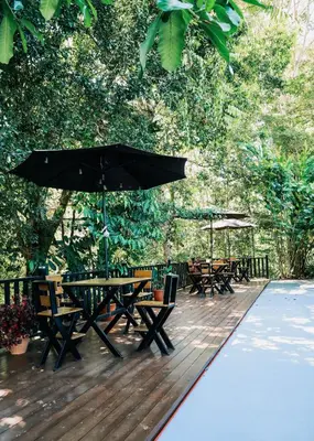 a wooden deck with picnic tables and an umbrella at Hotel y Restaurante El Páramo in San Rafael Norte