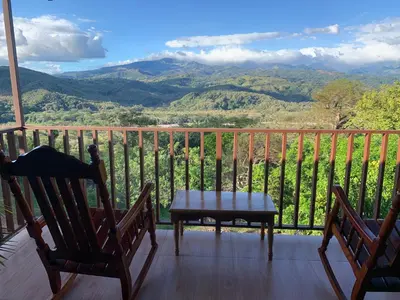 a table and two chairs on a balcony with mountains at Conectar con la naturaleza in Esparza