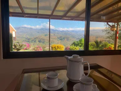 a tea kettle and cups on a glass table in front of a window at Conectar con la naturaleza in Esparza