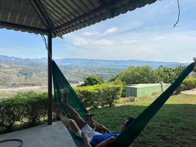 two people laying in a hammock with a view at Conectar con la naturaleza in Esparza