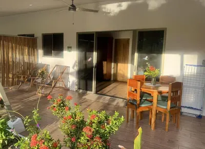a patio with a table and chairs and flowers at Apartments Nauyaca in Platanillo