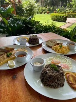 a wooden table with plates of food on it at Hotel Sol Sámara in Sámara