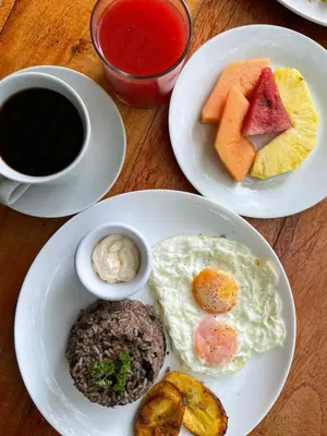 a table with plates of breakfast foods and a cup of coffee at Hotel Sol Sámara in Sámara