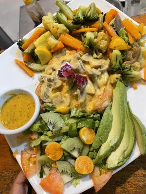 a plate of food with a salad and dipping sauce at Hotel Sol Sámara in Sámara