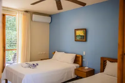 two beds in a bedroom with a blue wall at Hotel Sol Sámara in Sámara