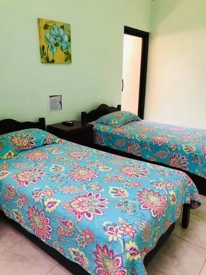 a bedroom with two beds with blue and pink sheets at Holiday Beach House In Punta Leona - wprivate Pool in Punta Leona
