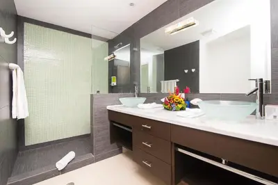 a bathroom with two sinks and a large mirror at Best in Jaco Condos at Diamante del Sol in Jacó