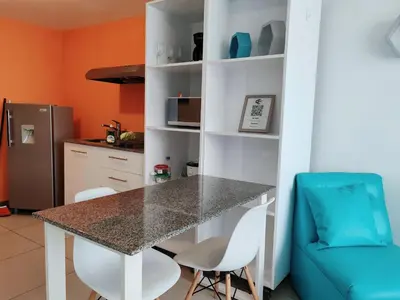 a kitchen with a table and chairs in a room at 0201 iFreses Hermoso Apartamento Full Equipado SIN PARQUEO in Curridabat