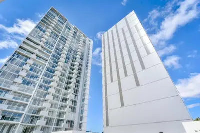 a tall white building next to a tall building at 0201 iFreses Hermoso Apartamento Full Equipado SIN PARQUEO in Curridabat