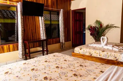 a room with two beds and a red door at Selvita Lodge Arenal in Fortuna