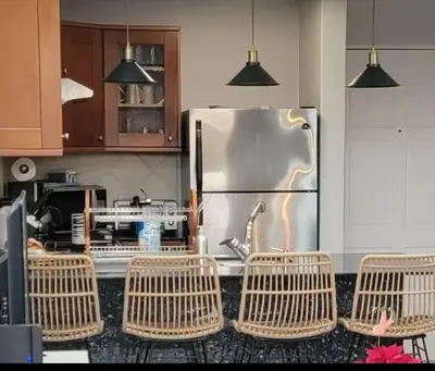 a kitchen with a stainless steel refrigerator and chairs at Cozy Resort Beach Condo in Playa Hermosa in Sardinal