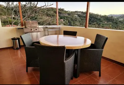 a table and chairs in a room with a large window at Cozy Resort Beach Condo in Playa Hermosa in Sardinal