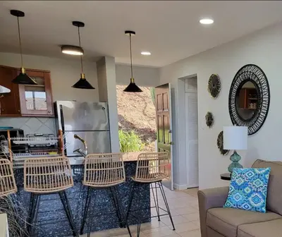 a living room with chairs and a kitchen at Cozy Resort Beach Condo in Playa Hermosa in Sardinal
