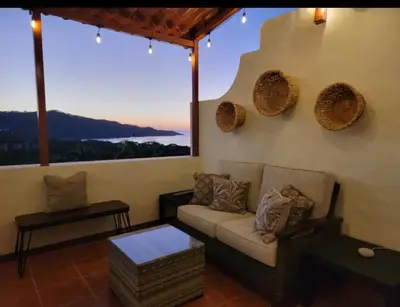 a living room with a couch and a large window at Cozy Resort Beach Condo in Playa Hermosa in Sardinal