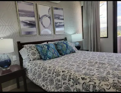 a bedroom with a bed and two lamps and pictures at Cozy Resort Beach Condo in Playa Hermosa in Sardinal