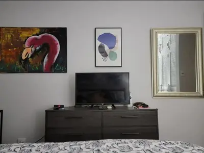 a bedroom with a dresser with a television and a mirror at Cozy Resort Beach Condo in Playa Hermosa in Sardinal