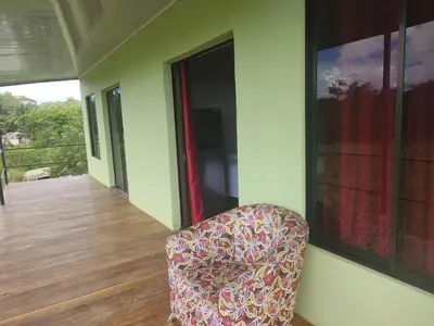 a chair sitting on the porch of a house at Cabinas equipadas Cóbano - Florida in Tambor