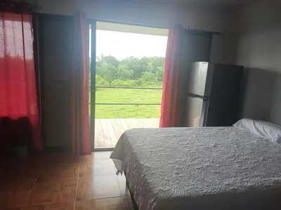 a bedroom with a bed and a large window at Cabinas equipadas Cóbano - Florida in Tambor