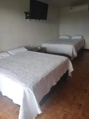 two beds in a room with a tv on the wall at Cabinas equipadas Cóbano - Florida in Tambor
