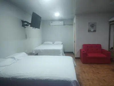 a room with two beds and a red chair at Cabinas equipadas Cóbano - Florida in Tambor