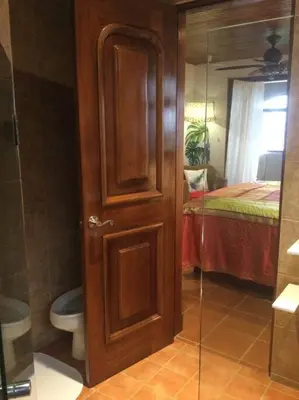 a bathroom with a toilet and a glass door at Lake Arenal Killer View Villa in Tilarán