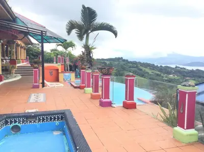 a pool with a hot tub next to a resort at Lake Arenal Killer View Villa in Tilarán