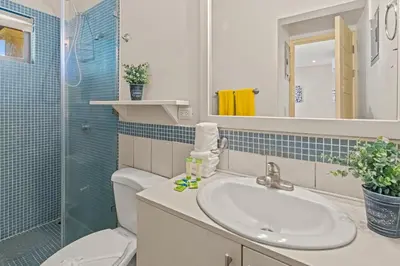 a bathroom with a sink and a toilet and a mirror at Beautiful beach front entire condo in Coco